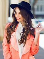 Close up  outdoor portrait of fashionable pretty woman   in casual bright spring or summer outfit , looking at camera, laughing.  Brunette  curly hairstyle. Bright sunny colors. photo