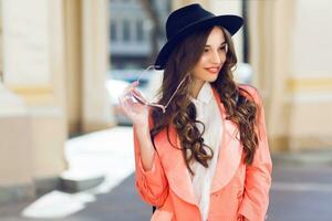 Close up  outdoor portrait of fashionable pretty woman   in casual bright spring or summer outfit , looking at camera, laughing.  Brunette  curly hairstyle. Bright sunny colors. photo