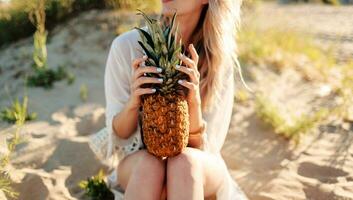 estilo de vida al aire libre imagen de mujer con jugoso piña relajante en soleado playa. foto