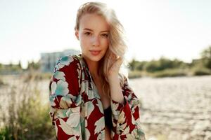 Fashion portrait of gorgeous blond woman with natural make up resting on sunny beach. Holidays mood photo