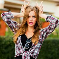 Young pretty blonde  girl with grimaces face looking at camera.  Funny  emotional face. photo