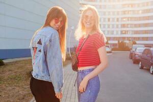 Lifestyle summer portrait of two beautiful women. Street style look. Gossip girls. photo