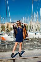 a woman sitting on a bench in front of boats photo