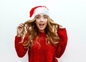 Surprise face. Ecstatic woman in red masquerade new year hat and sweater isolate on white background. photo