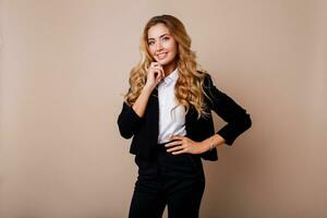 Shocked young business woman or employe in stylish  suit posing over beige background. photo