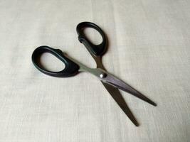 A pair of sharp scissors was wide open on table photo