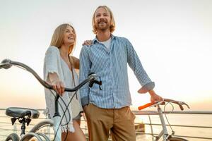 attractive happy couple traveling in summer on bicycles photo