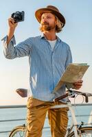 young attractive man traveling on bicycle by sea photo