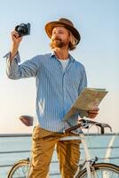 young attractive man traveling on bicycle by sea photo