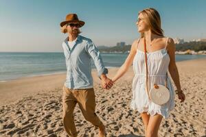 young attractive smiling happy man and woman running together on beach photo