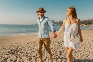 young attractive smiling happy man and woman running together on beach photo