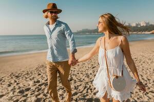 young attractive smiling happy man and woman running together on beach photo