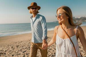 young attractive smiling happy man and woman running together on beach photo