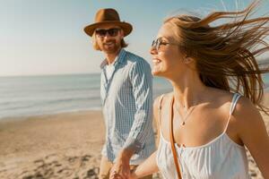 young attractive smiling happy man and woman running together on beach photo