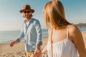 young attractive smiling happy man and woman running together on beach photo