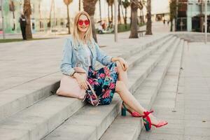 pretty smiling woman sitting in city street photo