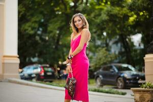 elegant attractive woman wearing pink sexy summer dress walking in street photo