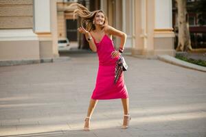 elegant attractive woman wearing pink sexy summer dress walking in street photo