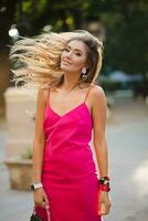 elegant attractive woman wearing pink sexy summer dress walking in street photo