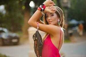 elegant attractive woman wearing pink sexy summer dress walking in street photo