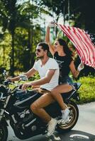 young couple in love, riding a motorcycle, hug, passion, free spirit, american flag photo