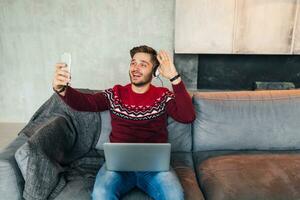 young attractive smiling man on sofa at home photo