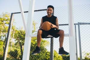 negro hombre haciendo Deportes, jugando baloncesto en amanecer, activo estilo de vida, soleado verano Mañana foto