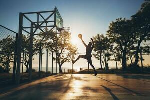 black man doing sports, playing basketball on sunrise, jumping silhouette photo