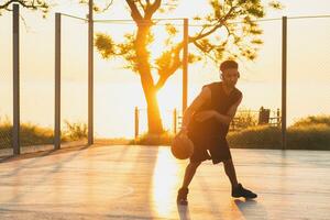 negro hombre haciendo Deportes, jugando baloncesto en amanecer, activo estilo de vida, soleado verano Mañana foto