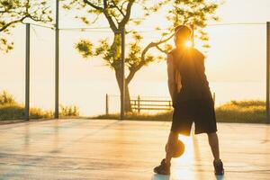 negro hombre haciendo Deportes, jugando baloncesto en amanecer, activo estilo de vida, soleado verano Mañana foto