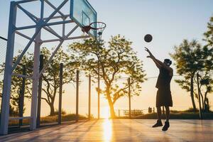 black man doing sports, playing basketball on sunrise, active lifestyle, sunny summer morning photo
