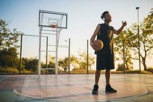 black man doing sports, playing basketball on sunrise, active lifestyle, sunny summer morning photo