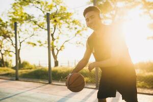 black man doing sports, playing basketball on sunrise, active lifestyle, sunny summer morning photo