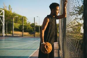 negro hombre haciendo Deportes, jugando baloncesto en amanecer, activo estilo de vida, soleado verano Mañana foto