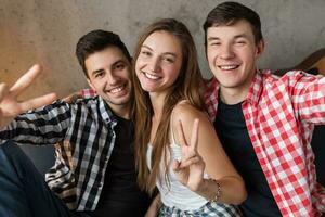 contento joven personas teniendo divertido, amigos fiesta a hogar foto