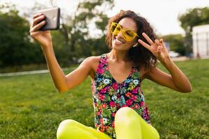 joven elegante negro mujer teniendo divertido en parque verano Moda estilo foto