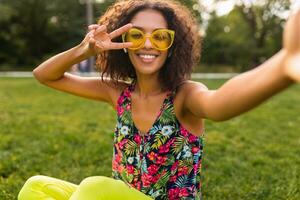 joven elegante negro mujer teniendo divertido en parque verano Moda estilo foto