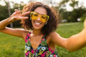 joven elegante negro mujer teniendo divertido en parque verano Moda estilo foto