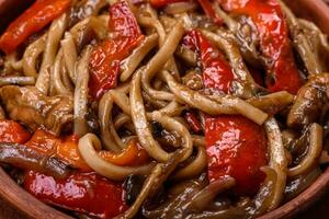 Delicious asian udon dish with vegetables, mushrooms, salt and spices photo