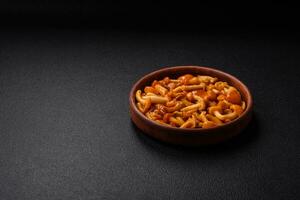 Delicious pickled honey mushrooms with salt and spices in a ceramic plate photo