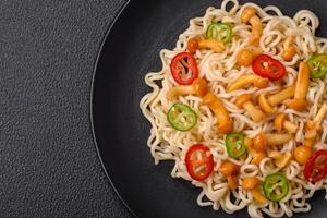 Delicious Asian cuisine dish with rice noodles, peppers, mushrooms and spices photo