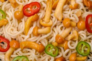 Delicious Asian cuisine dish with rice noodles, peppers, mushrooms and spices photo