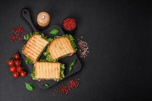 Delicious crispy sandwich with toast, salmon, avocado, tomatoes, salt, spices and herbs photo