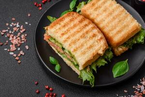 delicioso crujiente emparedado con tostada, salmón, palta, Tomates, sal, especias y hierbas foto