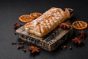 Delicious crispy braided bun with raisins inside and white icing outside photo