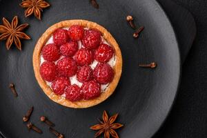 Delicious fresh sweet round tart with ripe raspberries and cream photo