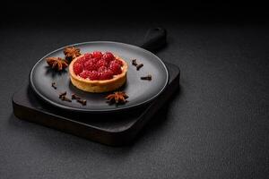 Delicious fresh sweet round tart with ripe raspberries and cream photo