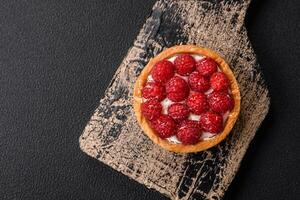 Delicious fresh sweet round tart with ripe raspberries and cream photo