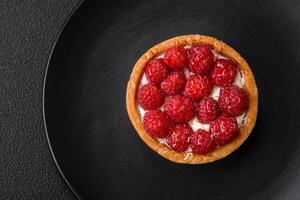 Delicious fresh sweet round tart with ripe raspberries and cream photo