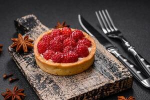 Delicious fresh sweet round tart with ripe raspberries and cream photo